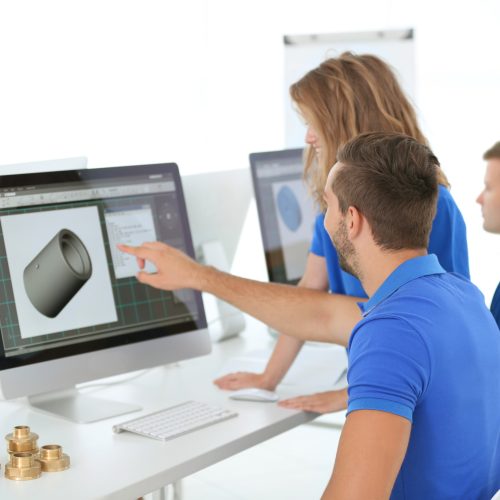 Young engineers planning project with CNC machinery in the office